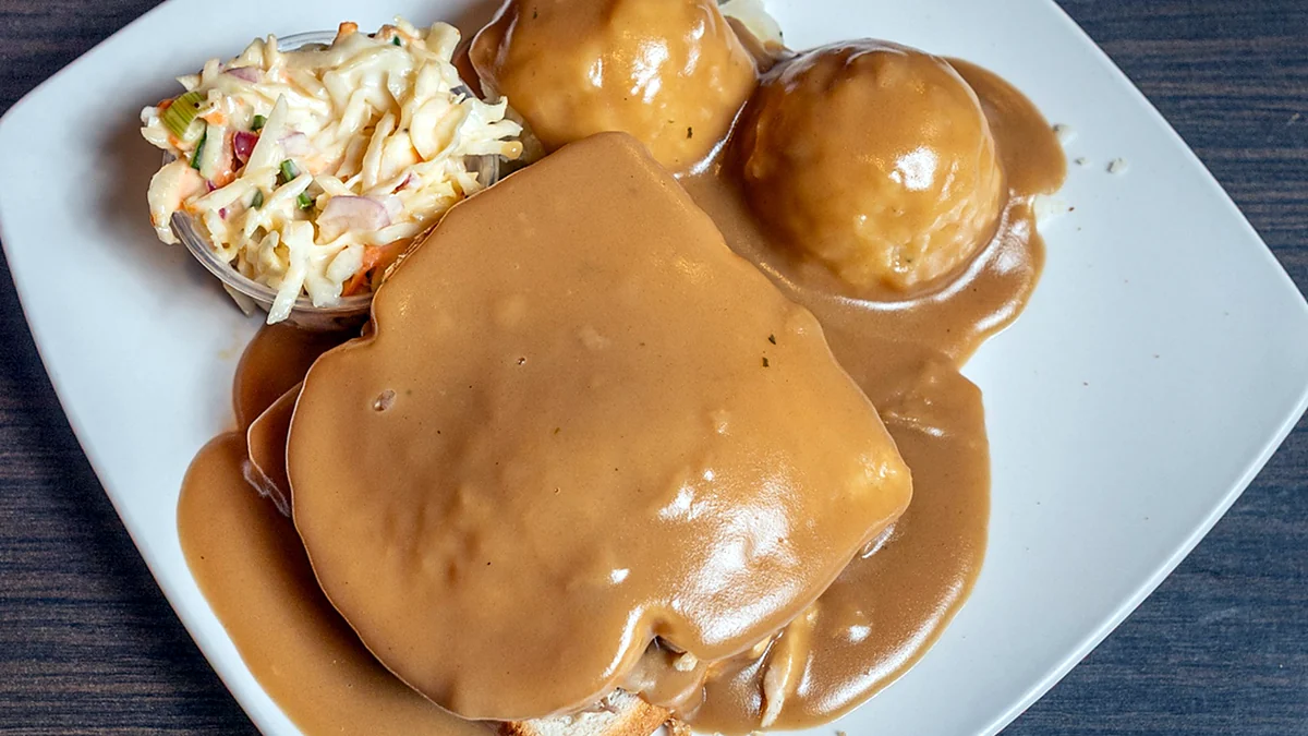 Hot turkey sandwich covered in gravy with mashed potatoes and coleslaw